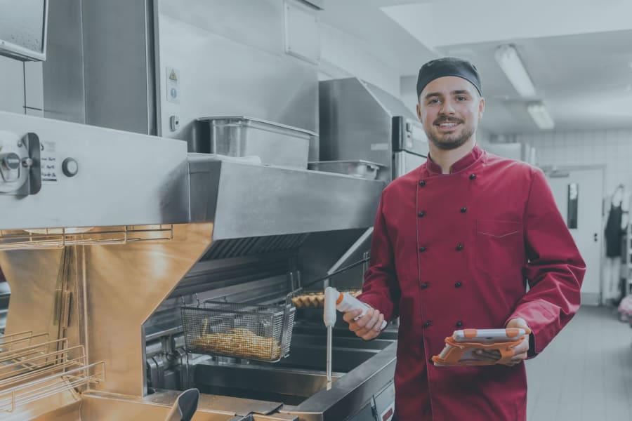 带着测量仪器在油炸锅前工作的员工