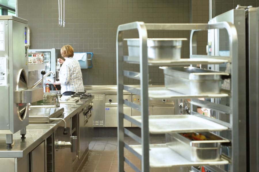 厨房景色，前景为上菜手推车，背景为员工