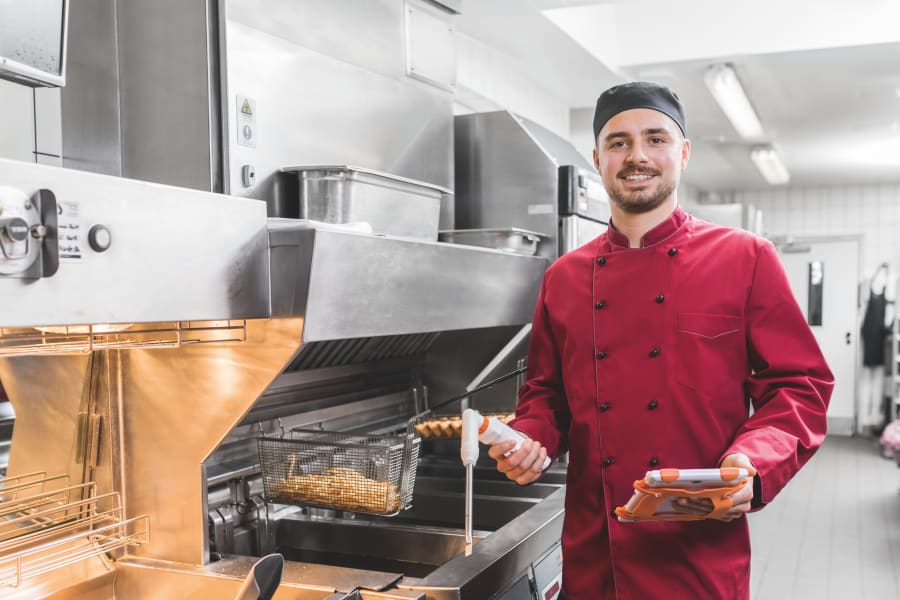 带着测量仪器在油炸锅前工作的员工