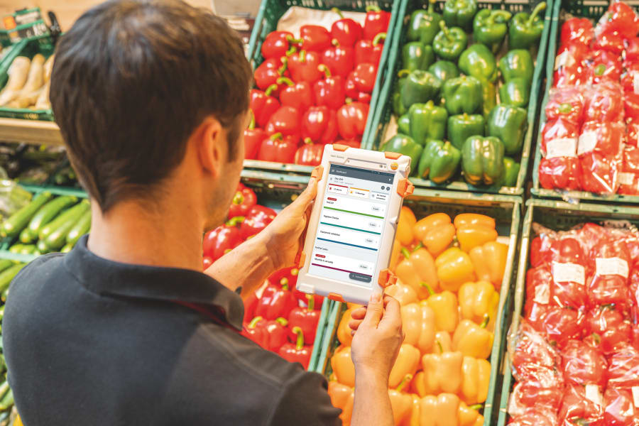 蔬菜部员工在质量控制过程中使用平板电脑